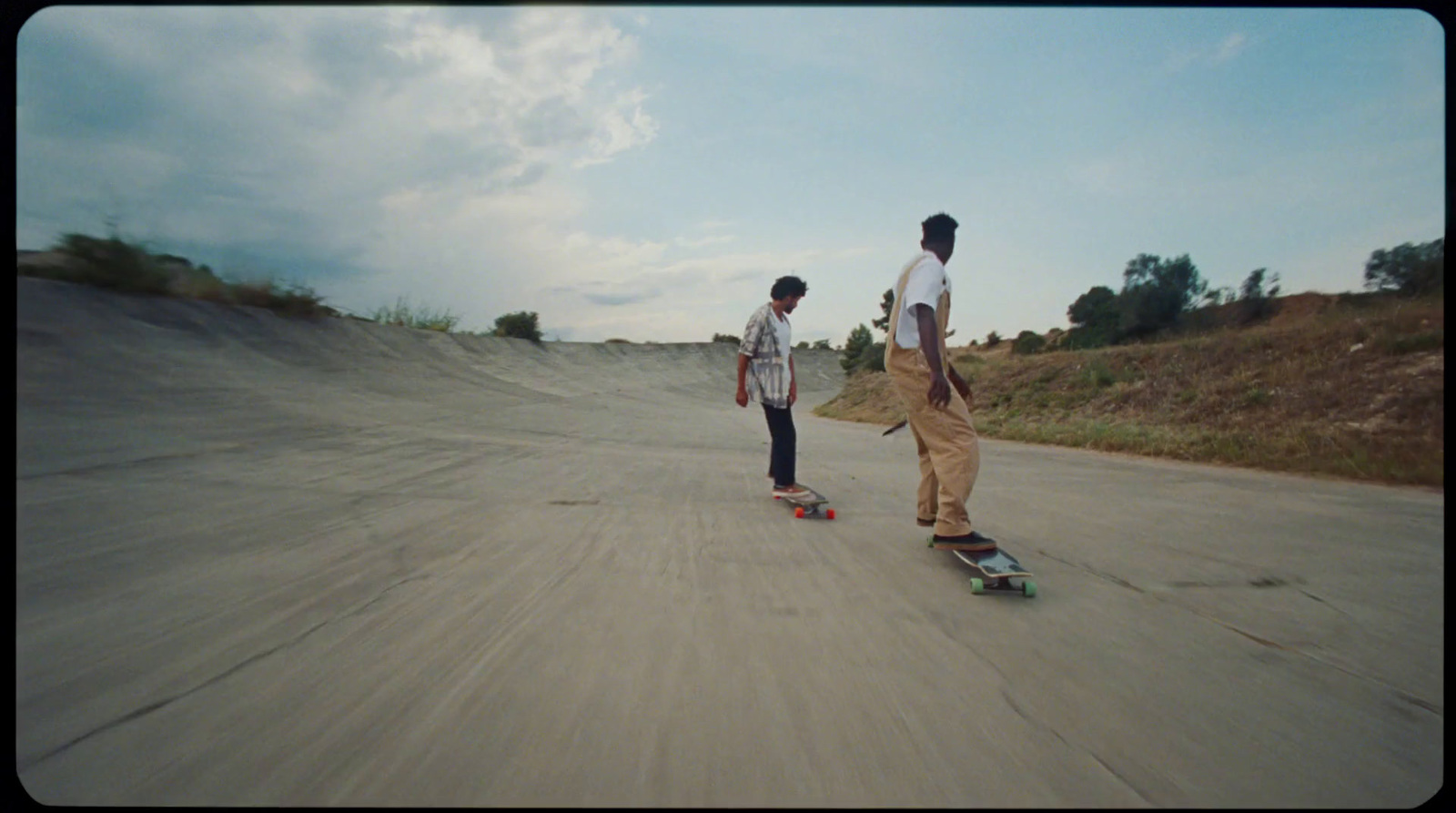 a couple of people riding skateboards down a street