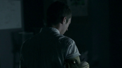 a man in a dark room with gloves on