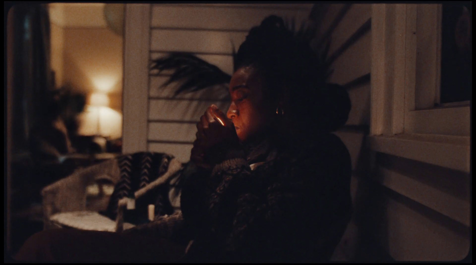 a woman sitting on a porch talking on a cell phone