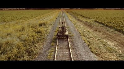 an aerial view of a train track in a field