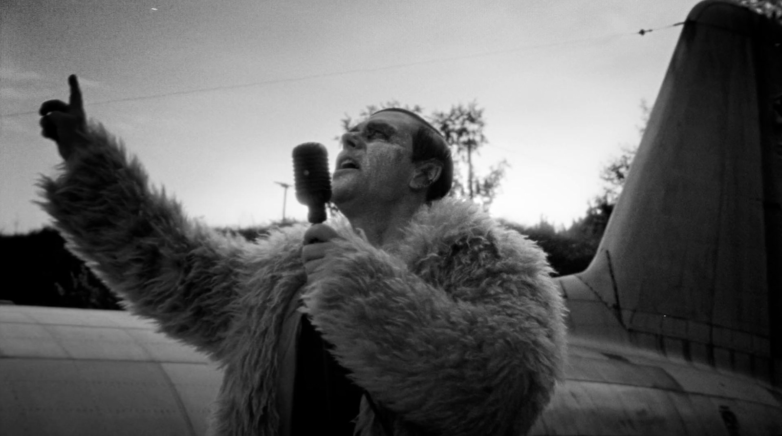 a man in a fur coat holding a cell phone