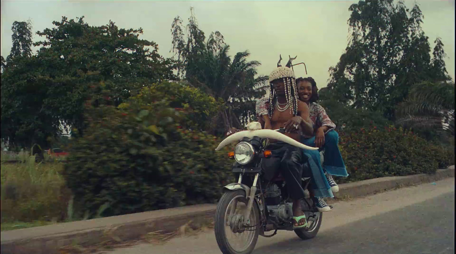 a man and woman riding on the back of a motorcycle