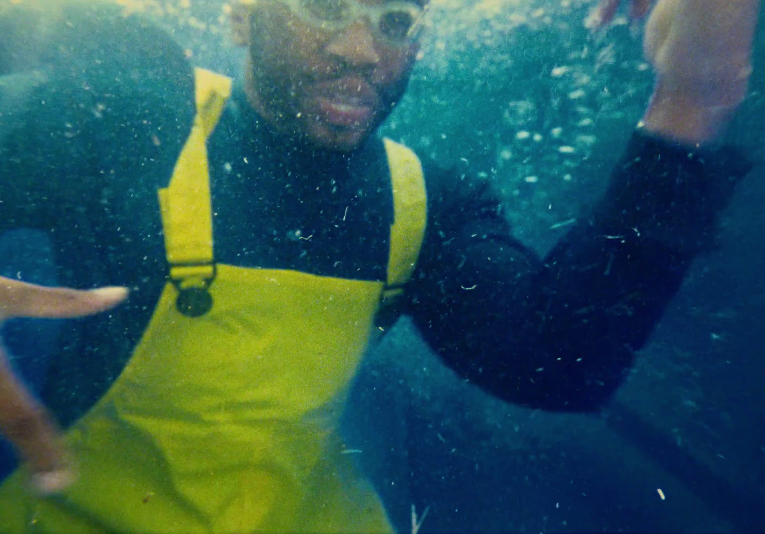 a man wearing a yellow bib under water