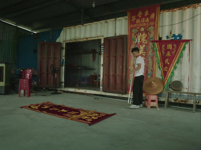 a man standing in front of a red and gold rug