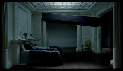 a dark room with a bed and a fireplace