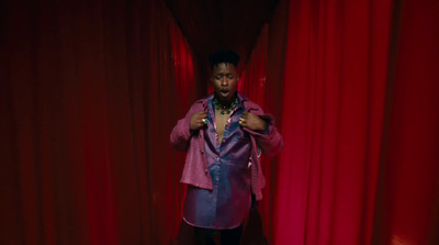 a woman standing in front of a red curtain