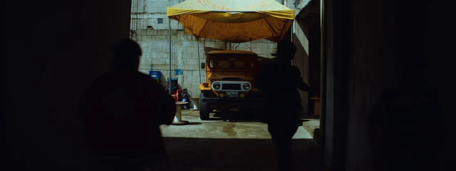 a person standing in a doorway with a yellow umbrella