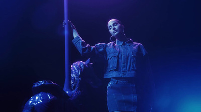 a woman standing next to a pole on a stage