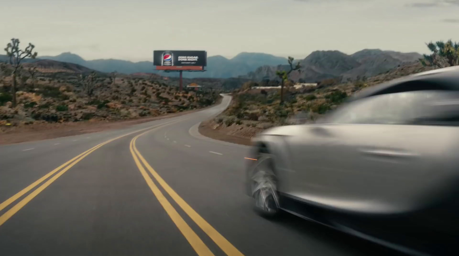 a car driving down a road with a sign in the background