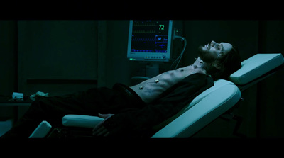 a man laying on a hospital bed in the dark