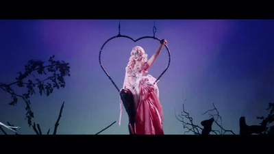 a woman in a pink dress holding a heart shaped object