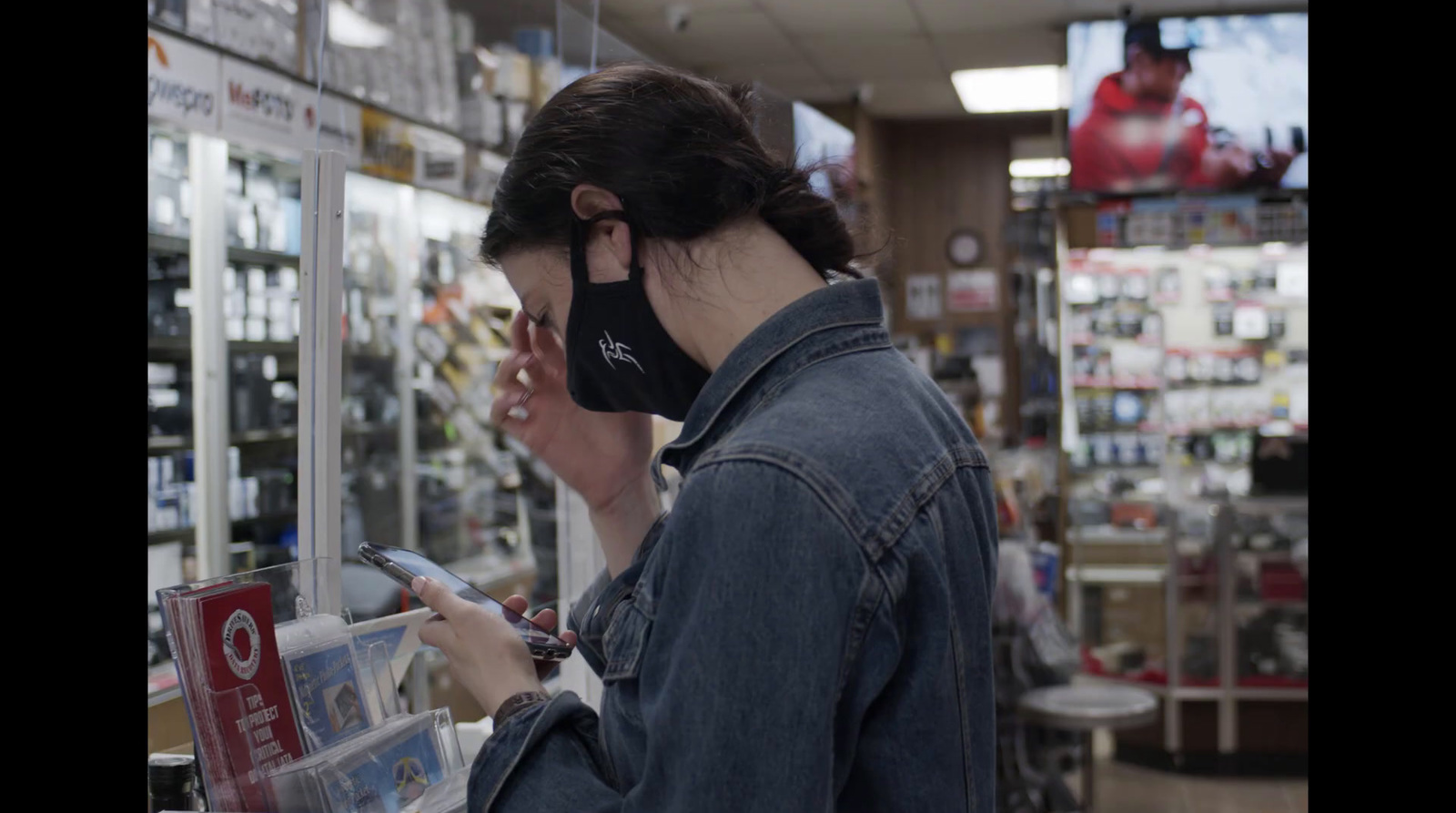 a woman wearing a face mask while looking at a cell phone