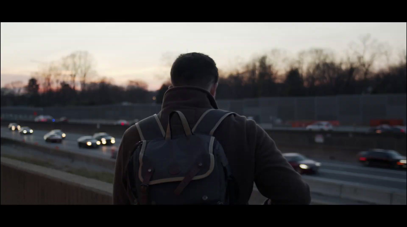 a man with a backpack walking down a highway