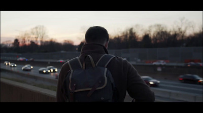 a man with a backpack walking down a highway