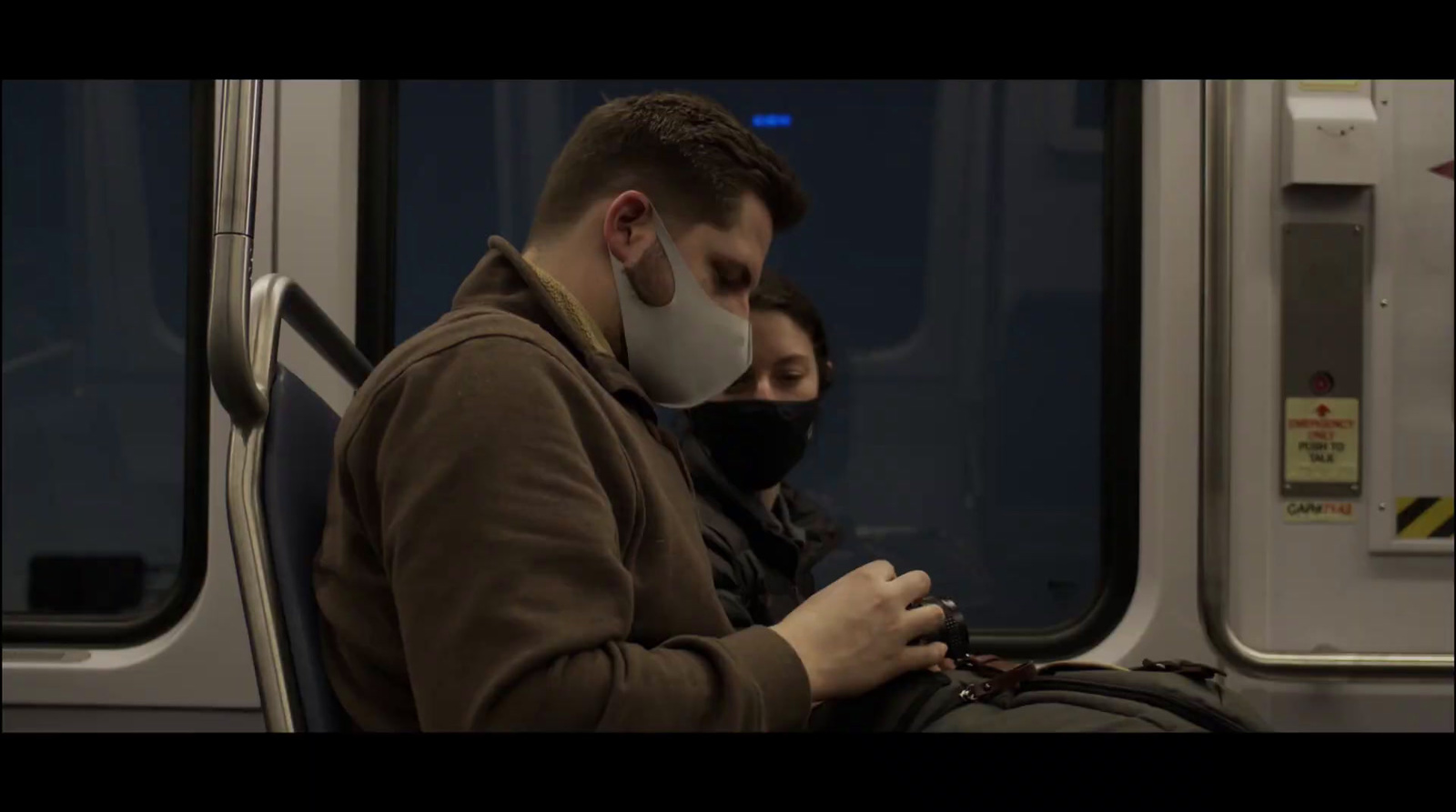 a man and a woman wearing face masks on a train