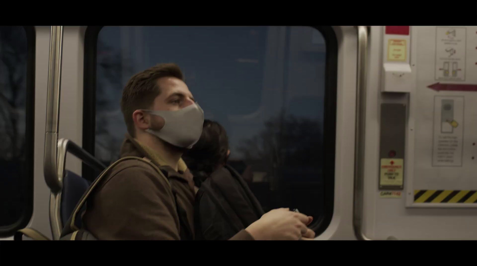 a man wearing a face mask on a train