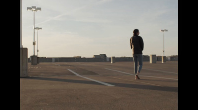 a man standing in an empty parking lot