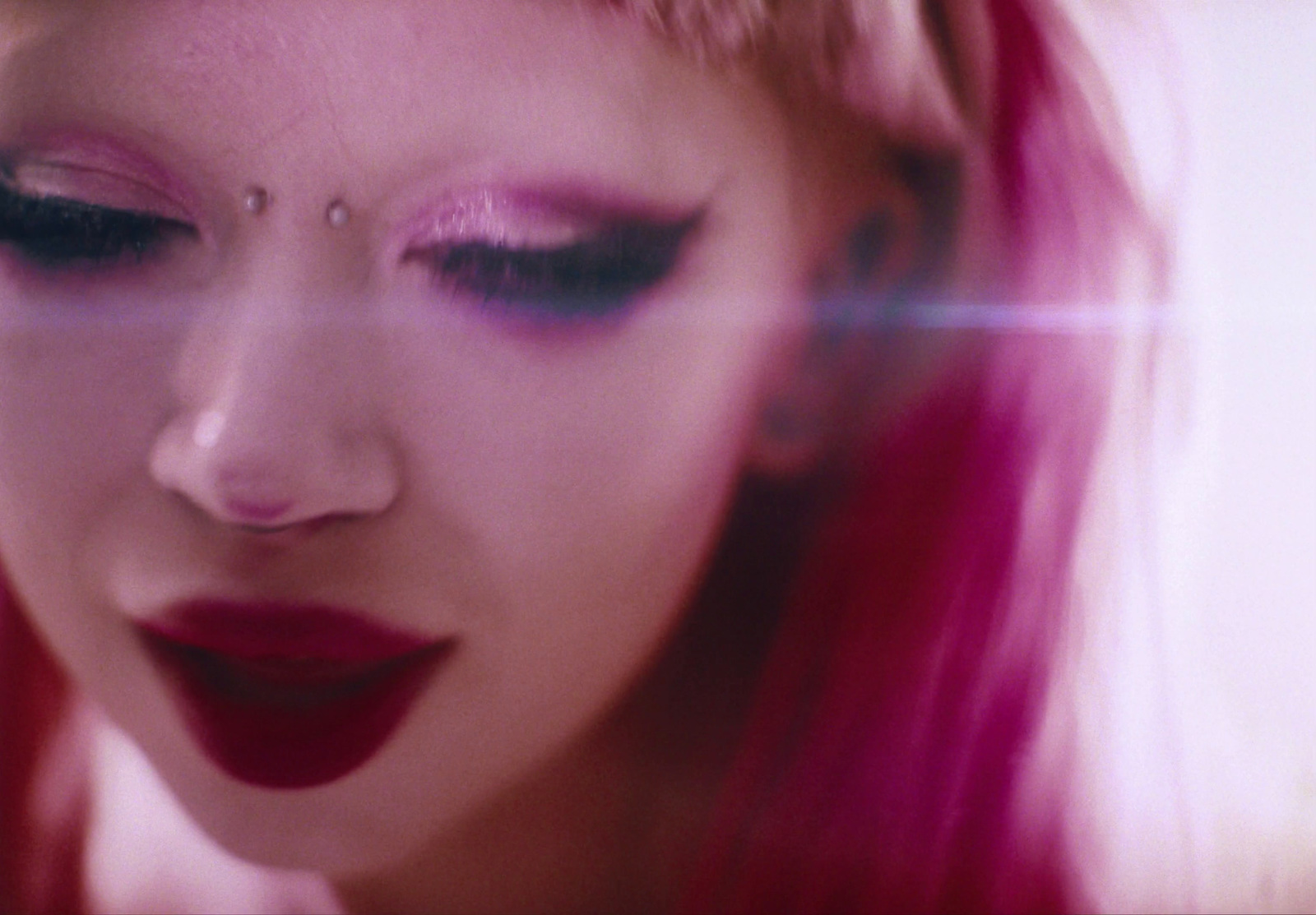 a close up of a woman with pink hair