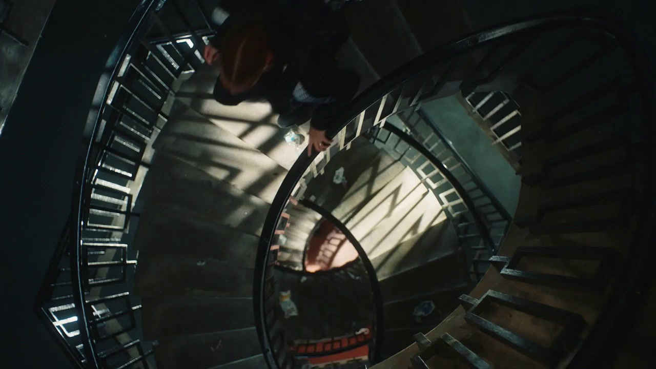 a man walking down a spiral staircase in a building