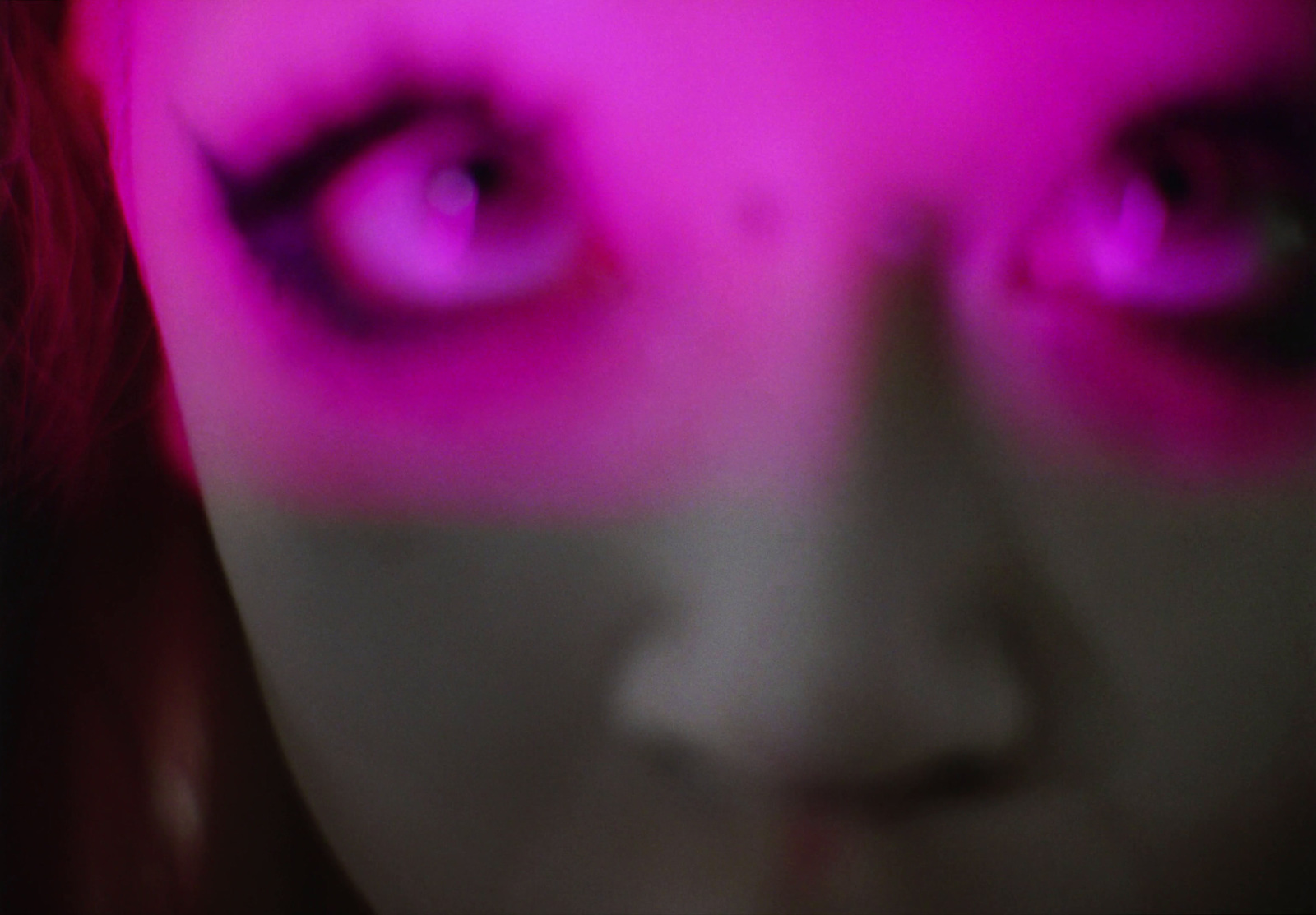 a close up of a woman's face with purple eyes