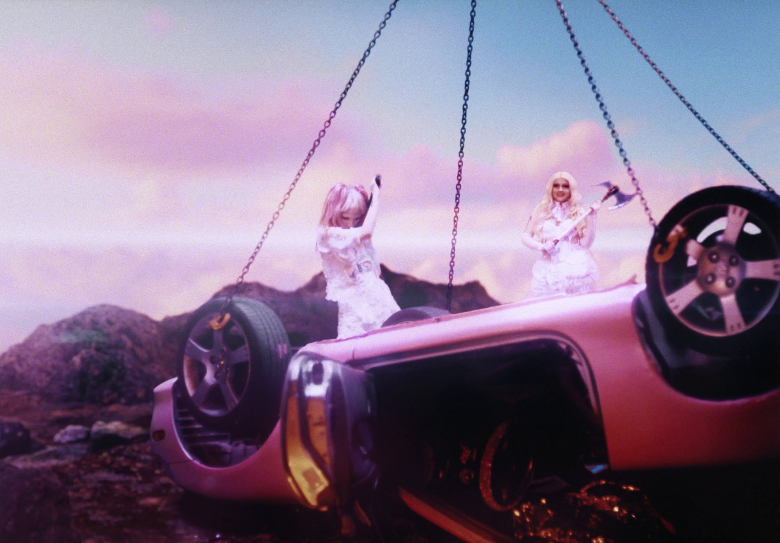 a couple of women standing on top of a pink car