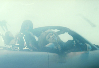 a woman sitting in a car talking on a cell phone