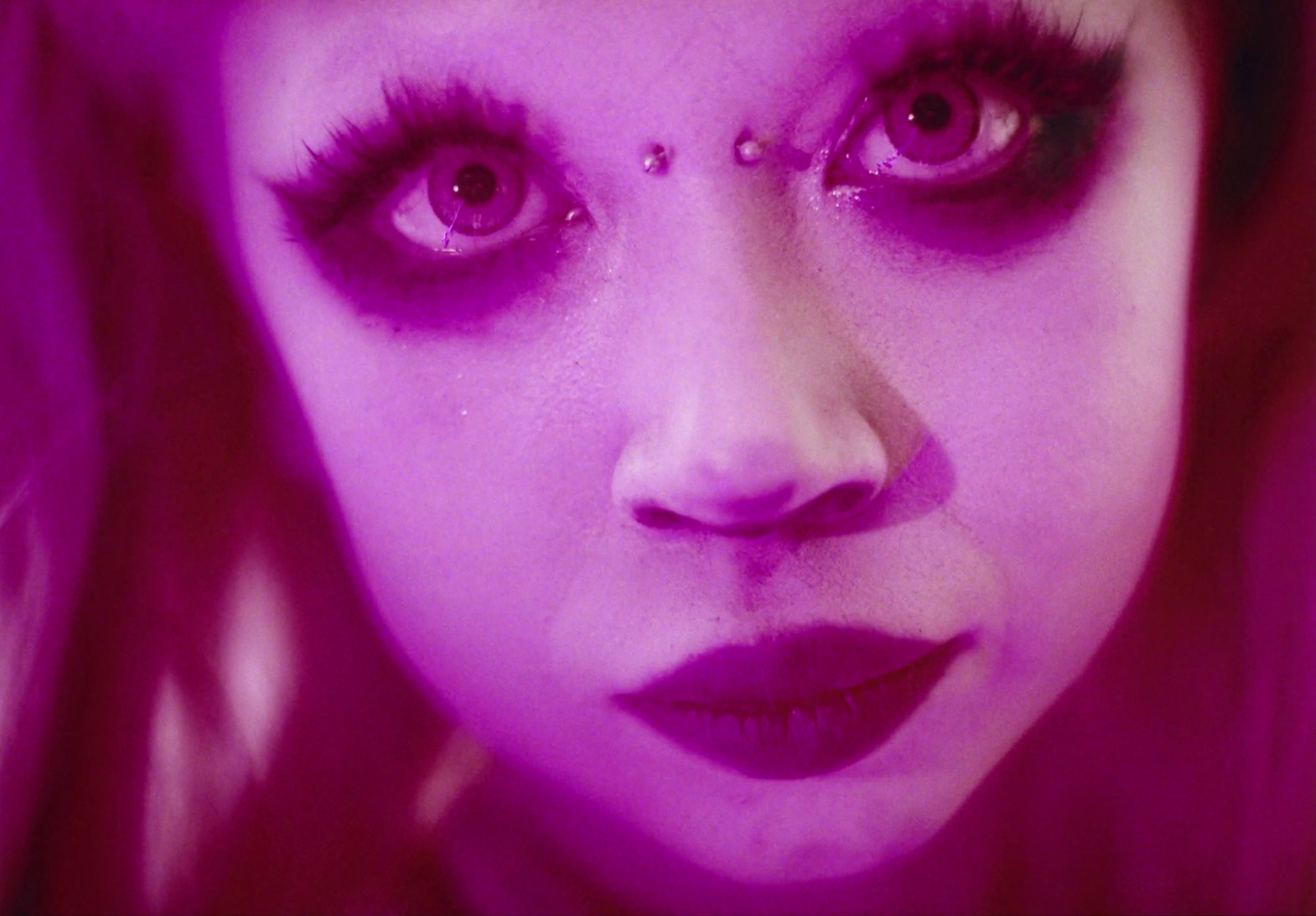 a close up of a woman with purple makeup