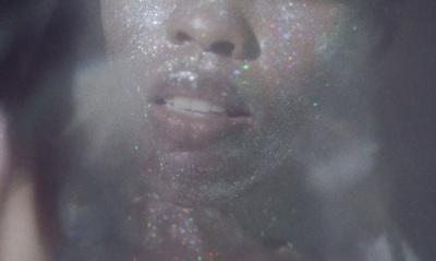 a woman with glitter on her face looking at the camera