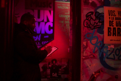 a man standing in front of a wall covered in graffiti