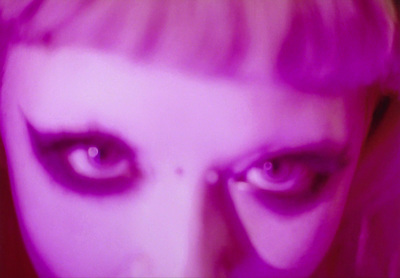 a close up of a woman's face with purple light