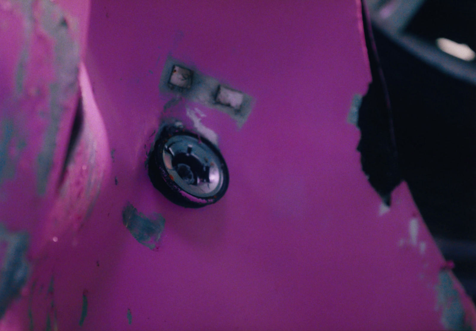 a close up of a button on a pink skateboard