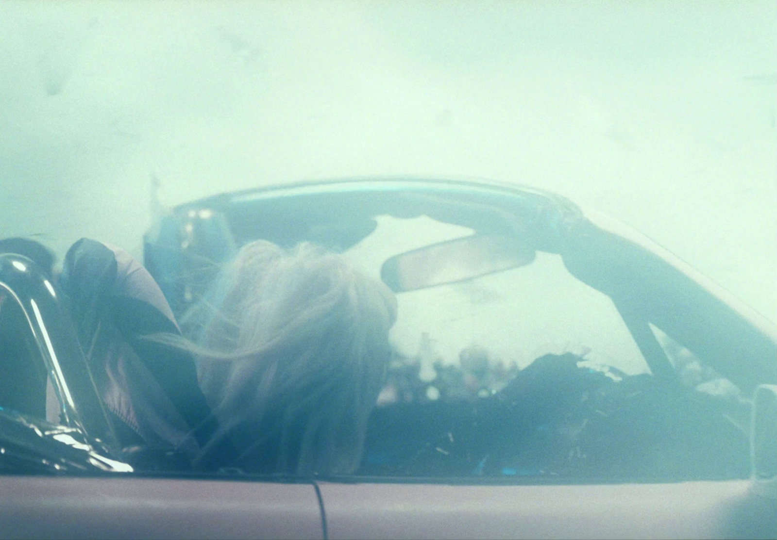 a woman sitting in the driver's seat of a car