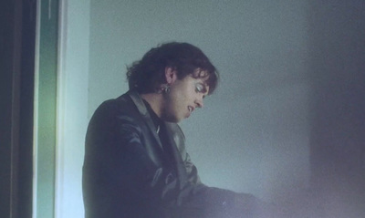 a man in a dark room looking at a laptop