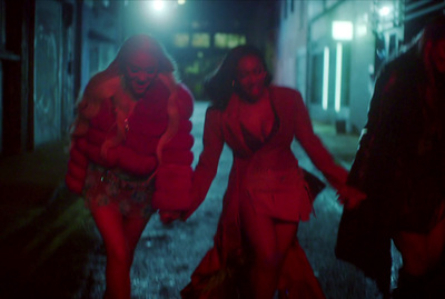 a group of women walking down a street at night