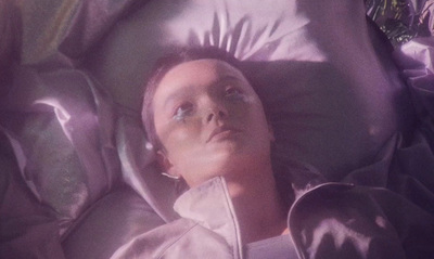 a woman laying in a bed with her eyes closed