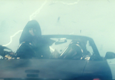 a woman sitting in a car in the rain