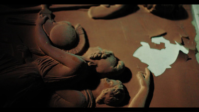 a sculpture of a woman laying on top of a table