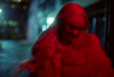 a woman in a red coat is walking down the street