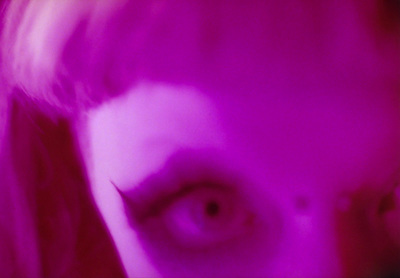 a blurry image of a woman's face with a purple background