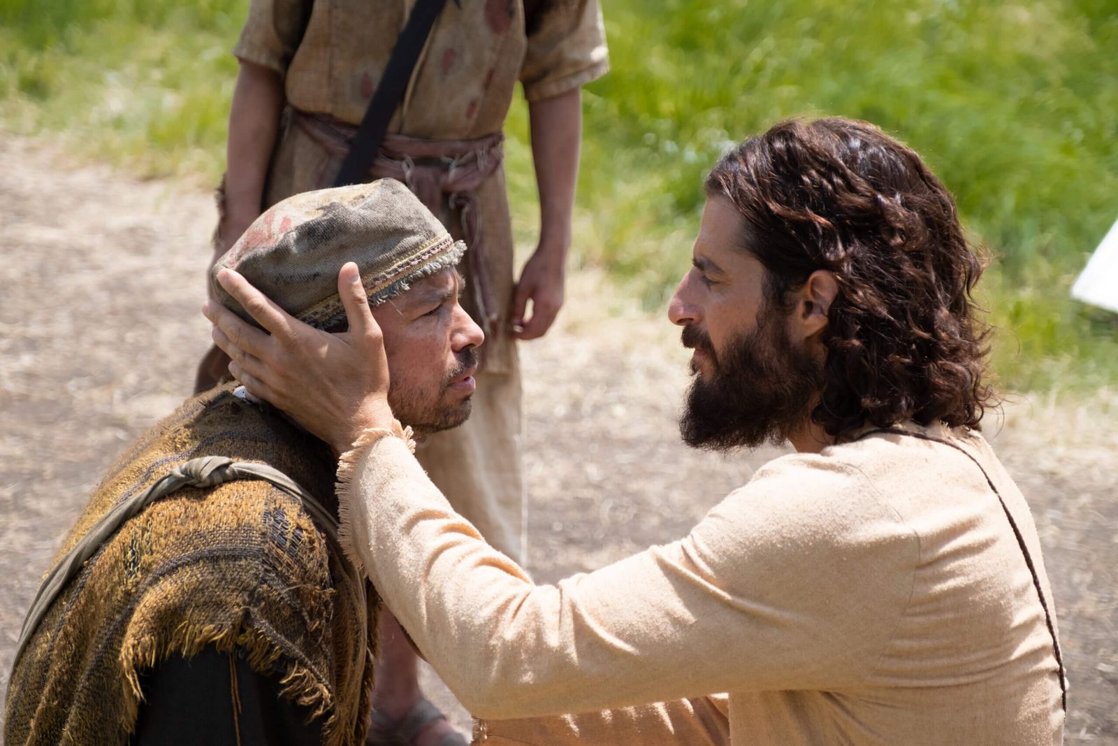 a man with a beard is touching another man's face