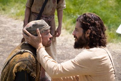 a man with a beard is touching another man's face