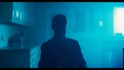 a man standing in a kitchen in the dark