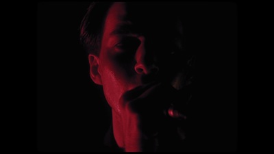 a man with his hand on his mouth in the dark