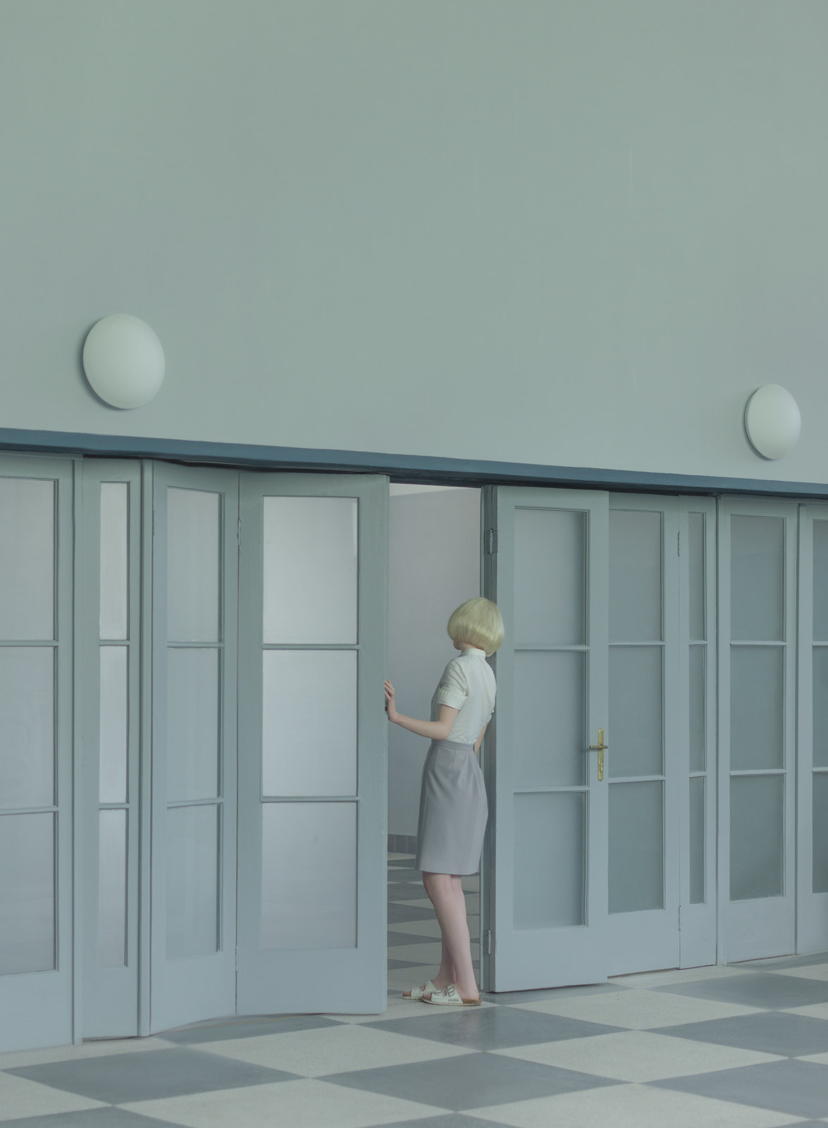 a woman in a gray dress standing in a room