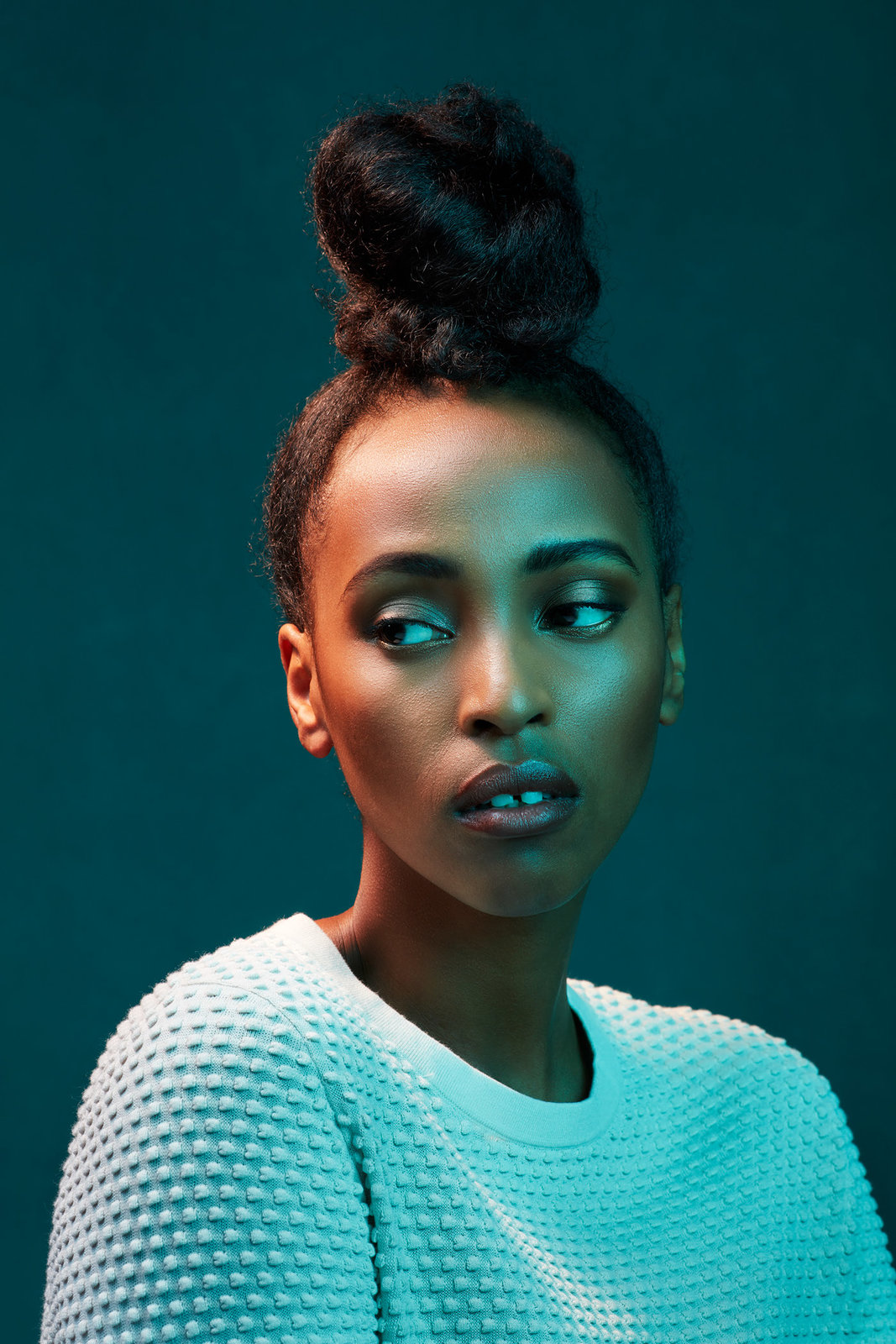 a woman with blue eyes and a white sweater