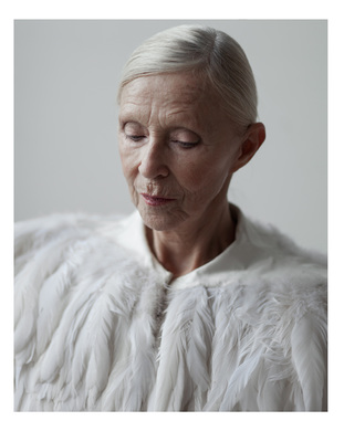 an older woman wearing a white feather coat