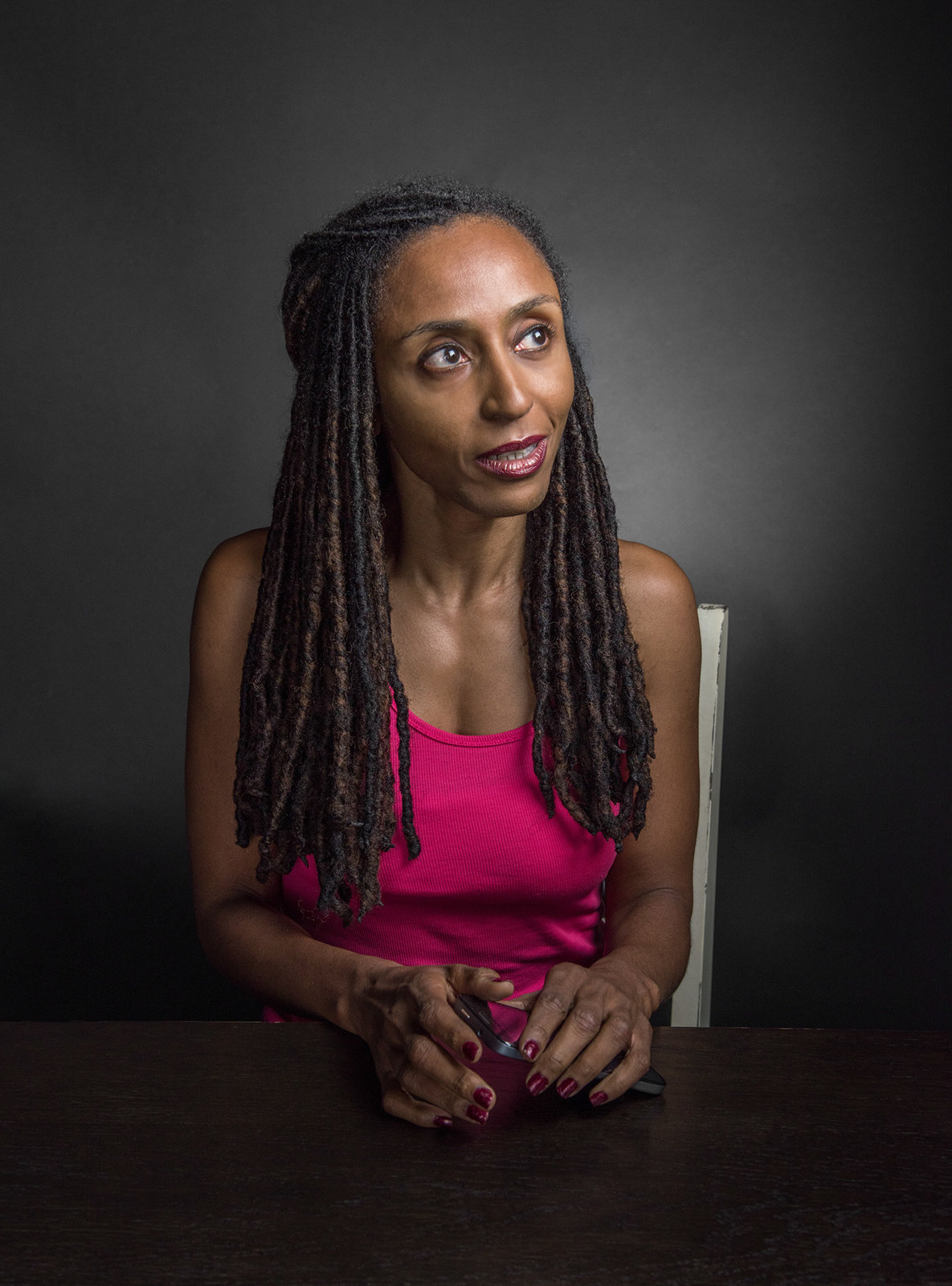 a woman with dreadlocks sitting at a table