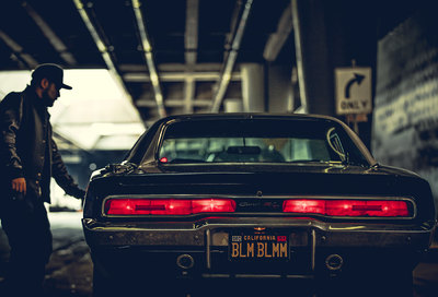 a man standing next to a car in a parking garage