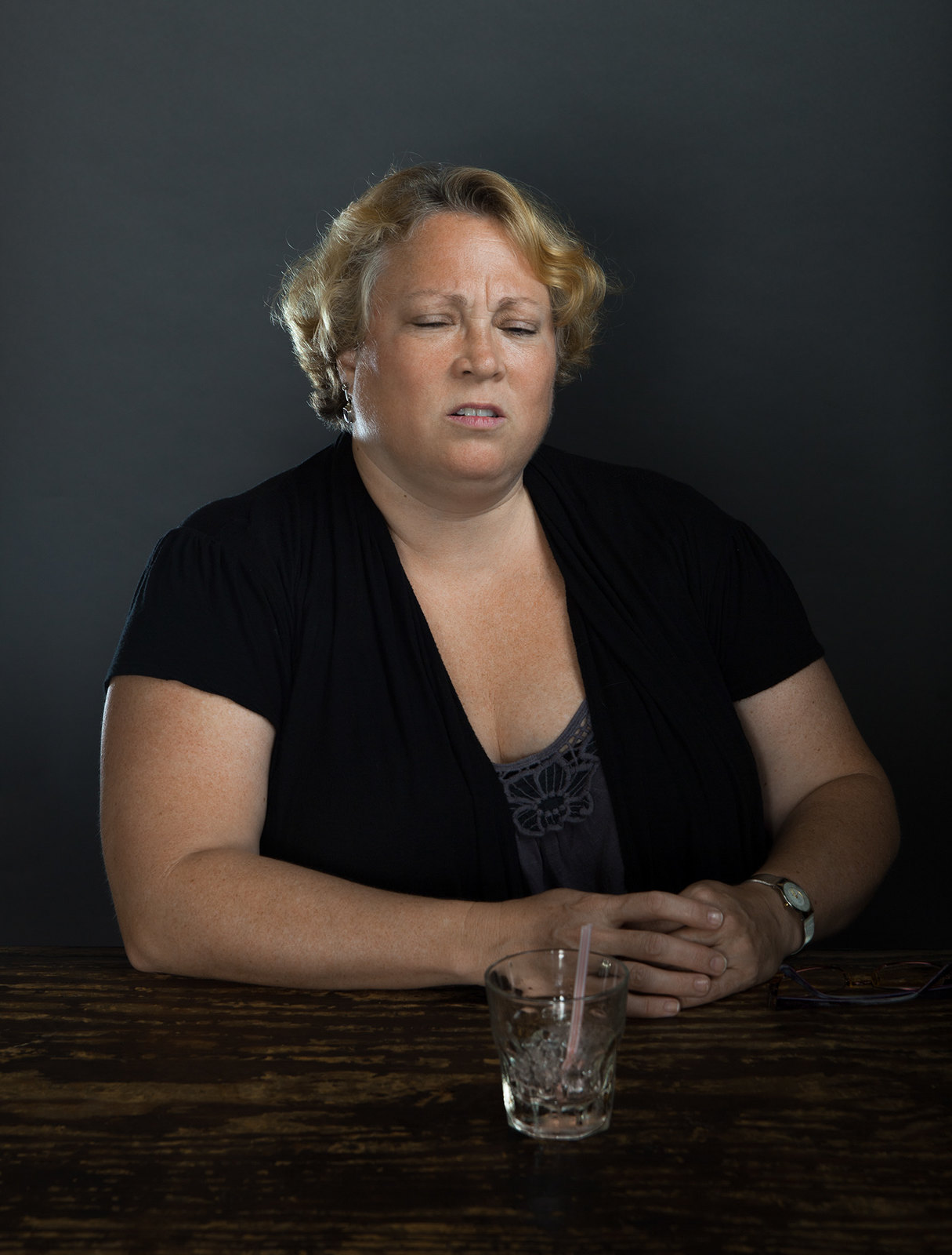 a woman sitting at a table with a glass of water