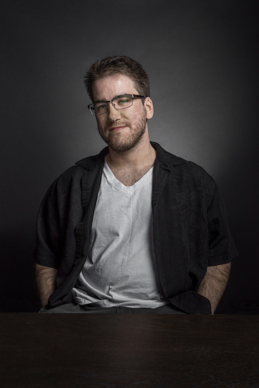 a man with glasses sitting at a table